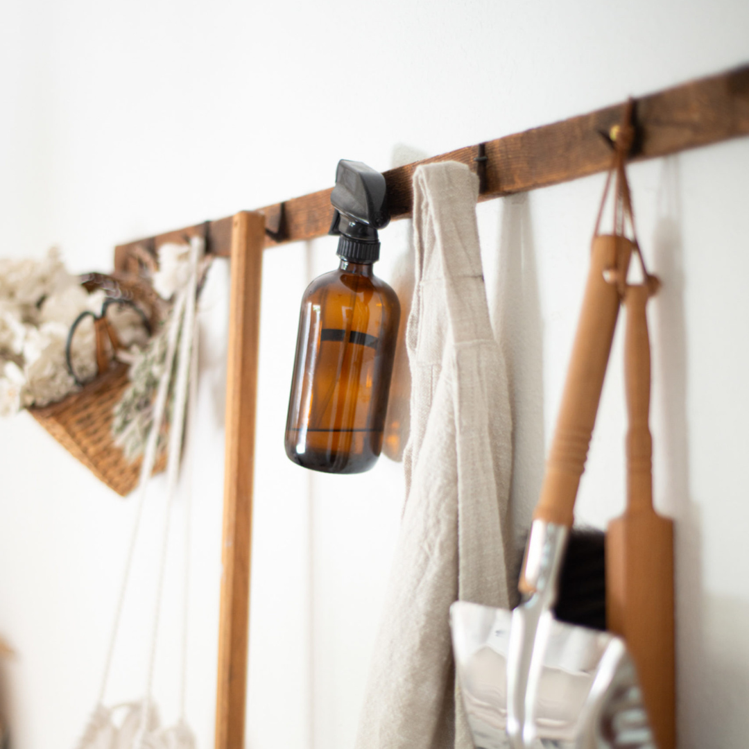 image of Cleaning supplies hanging on a peg rack to accompany a blog post about 20 spring clean up ideas for busy moms